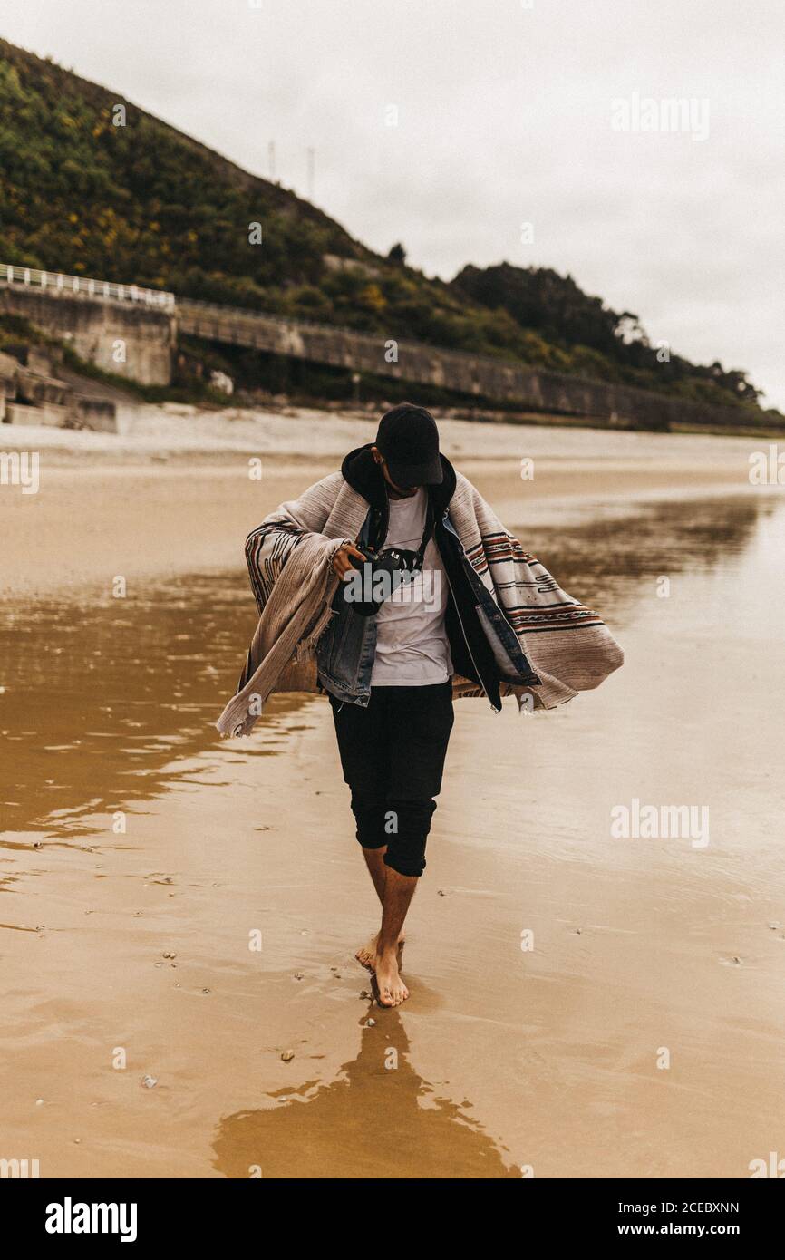 anonymous person walking on wet coast Stock Photo