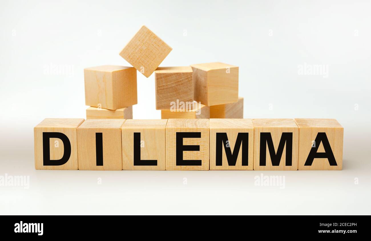DILEMMA - word written on wooden cubes on a yellow background Stock Photo