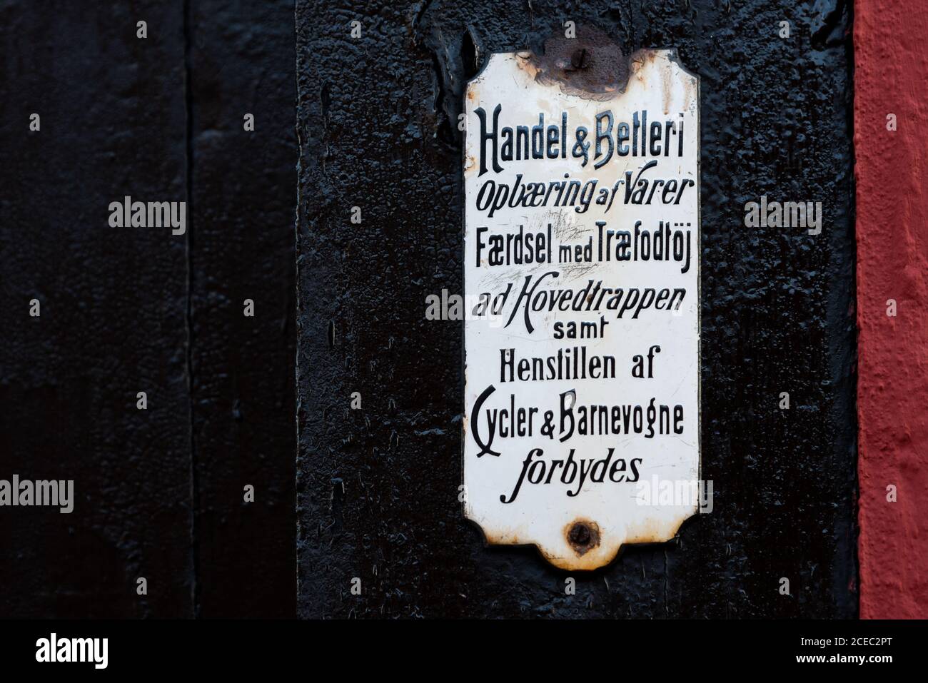 A white Old danish sign on a black wall, panhandling forbidden, Faaborg, Denmark, August 16, 2020 Stock Photo