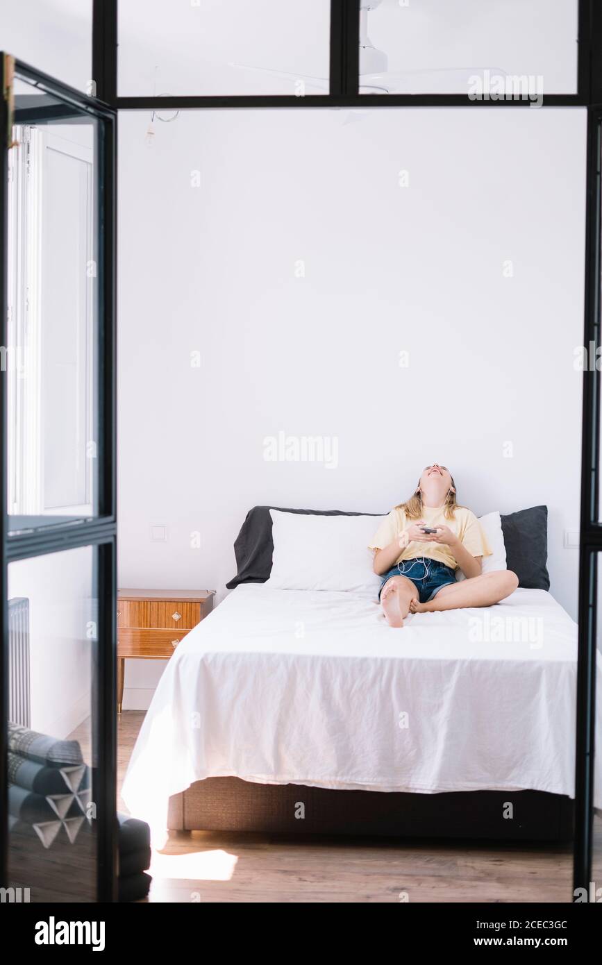 Relaxing Woman using phone on bed Stock Photo