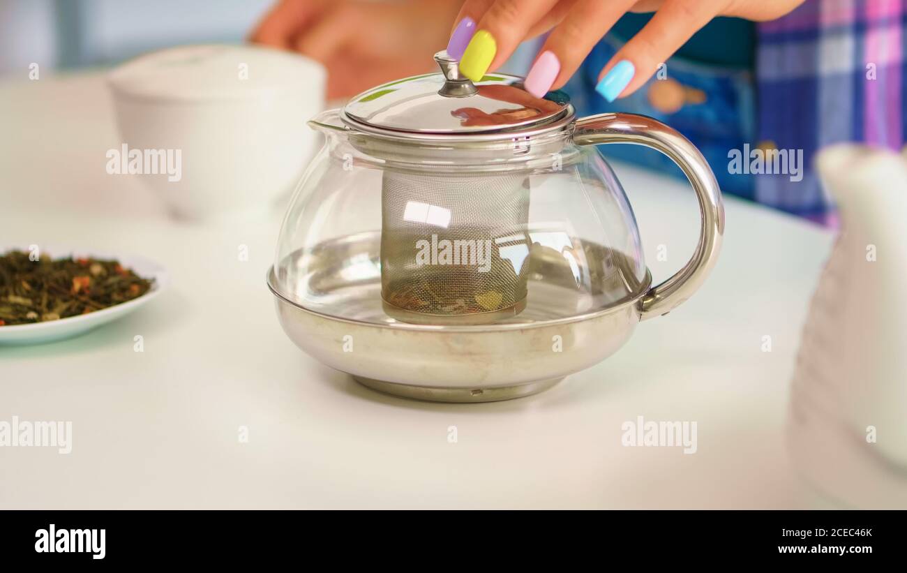 Close up of a woman brewing green tea in the morning, for breakfast, in ...