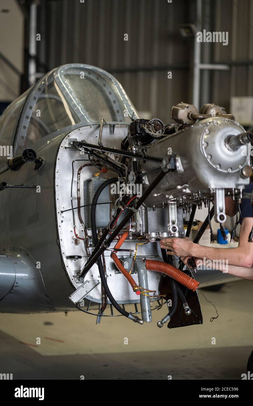 Crop hands of aircraft mechanic fixing engine of small airplane in hangar Stock Photo
