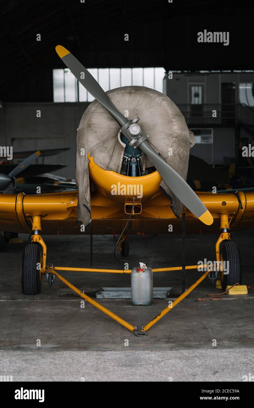 Close-up shot of airscrew on nose cone of small plane standing in hangar Stock Photo