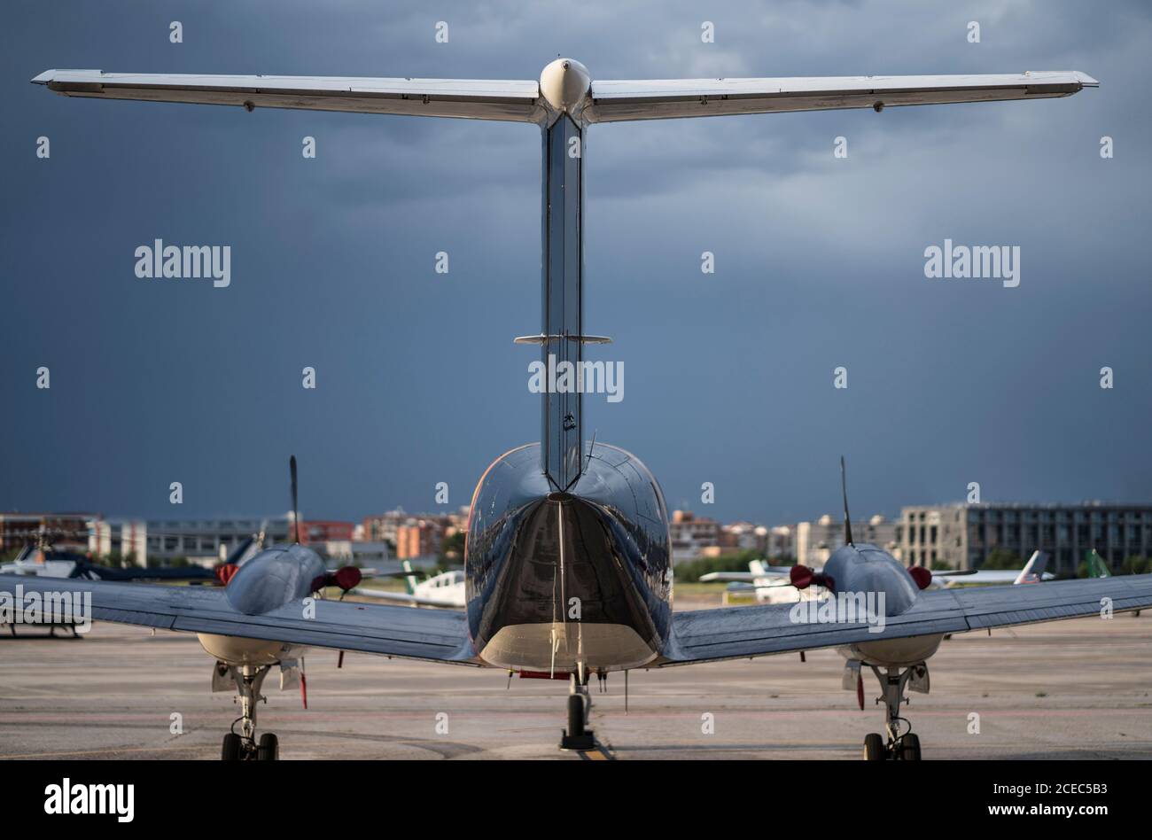 Nice aircraft standing on ground of civil airfield in town on cloudy weather Stock Photo
