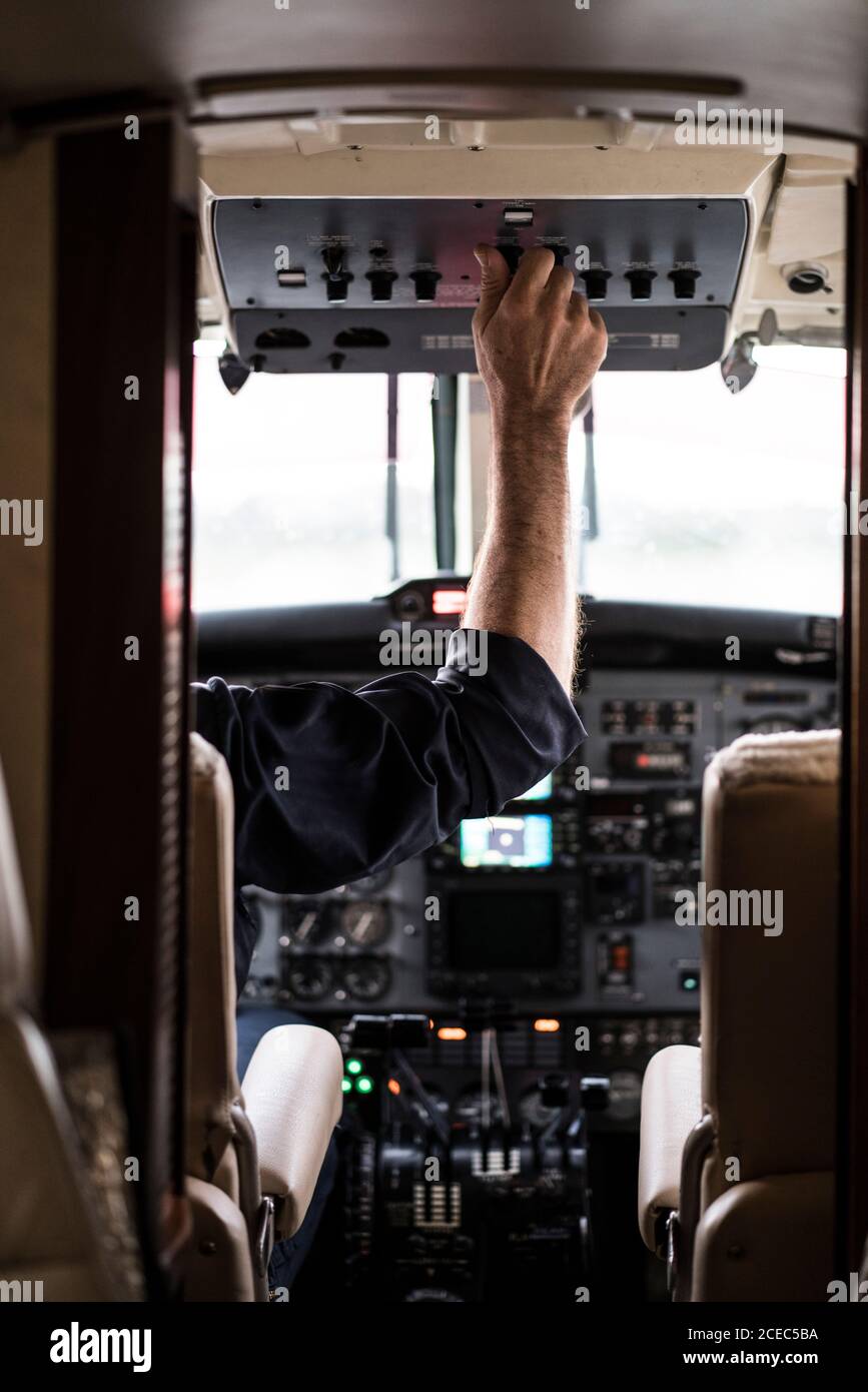 unrecognizable man in headset piloting plane?alone while sitting in ...