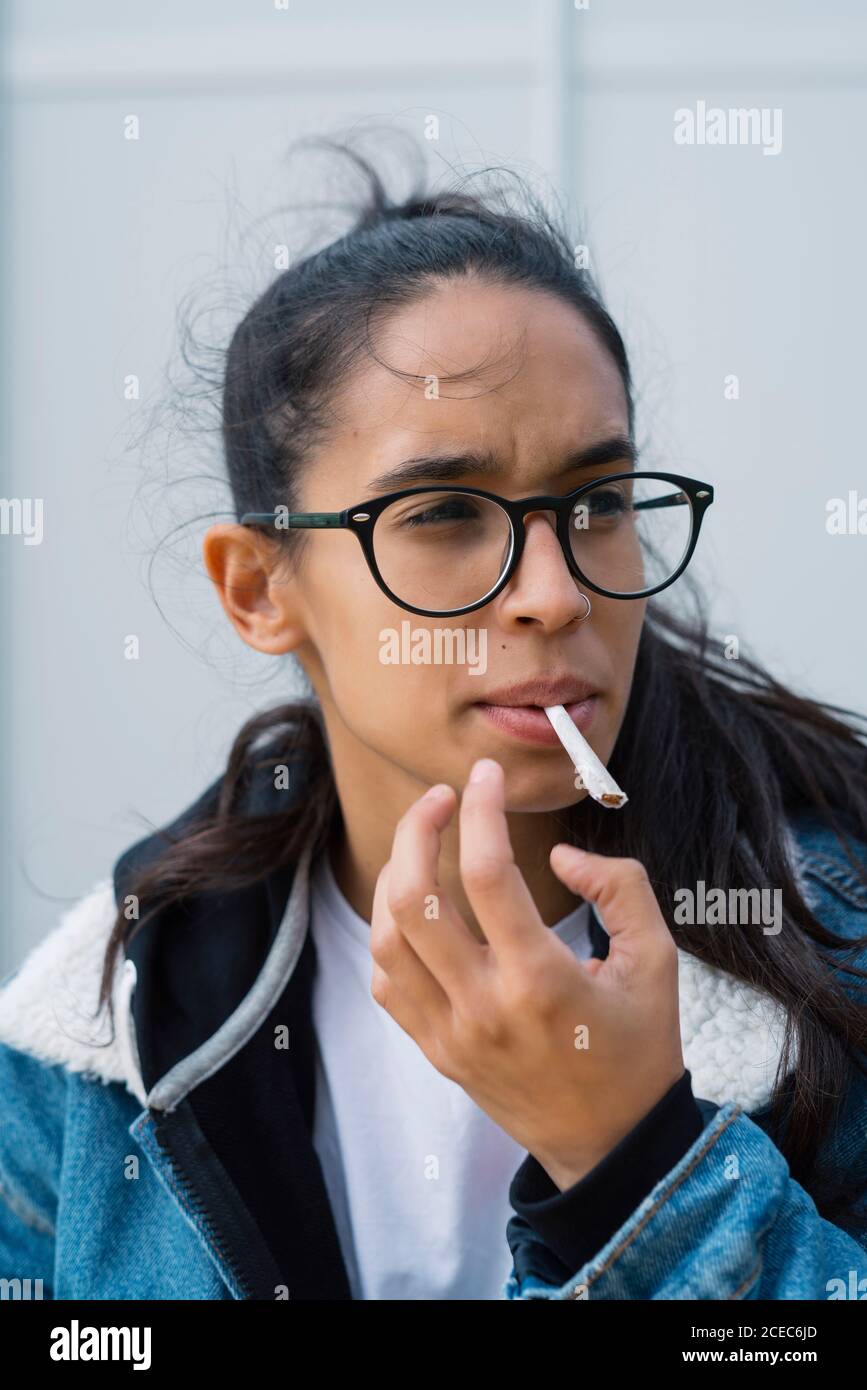 Beautiful young woman lighting cigarette hires stock photography and images Alamy