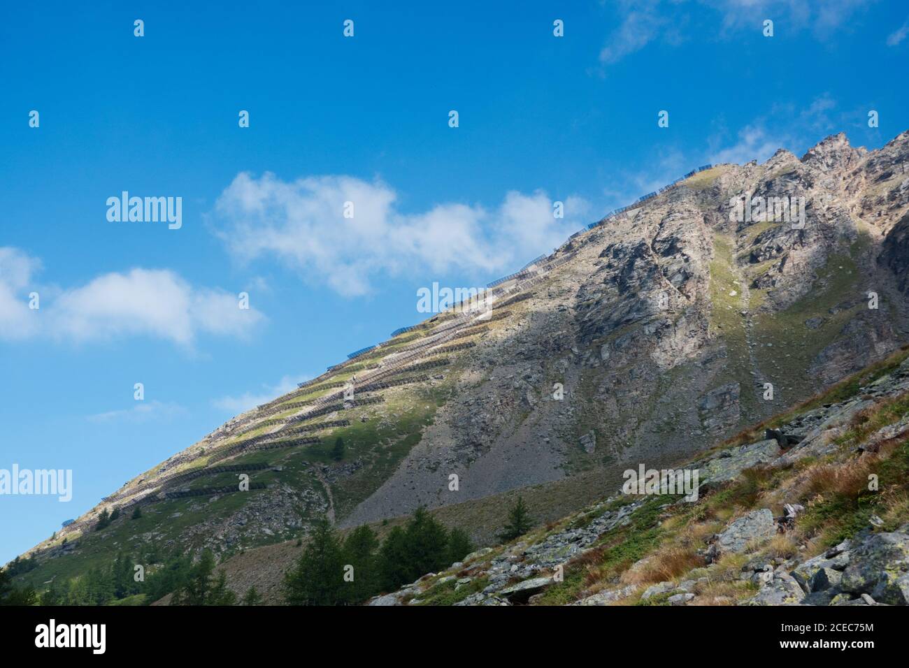 Avalanche barriers on the slope of mountains above the Simplon pass in Switzerland Stock Photo