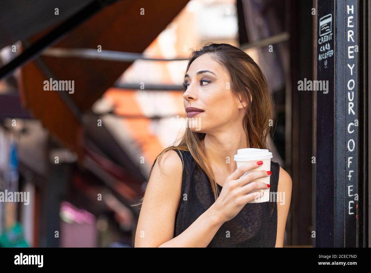 Woman with drink near outdoor cafe Stock Photo