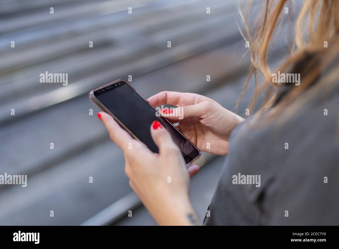Woman using smartphone on railway station Stock Photo