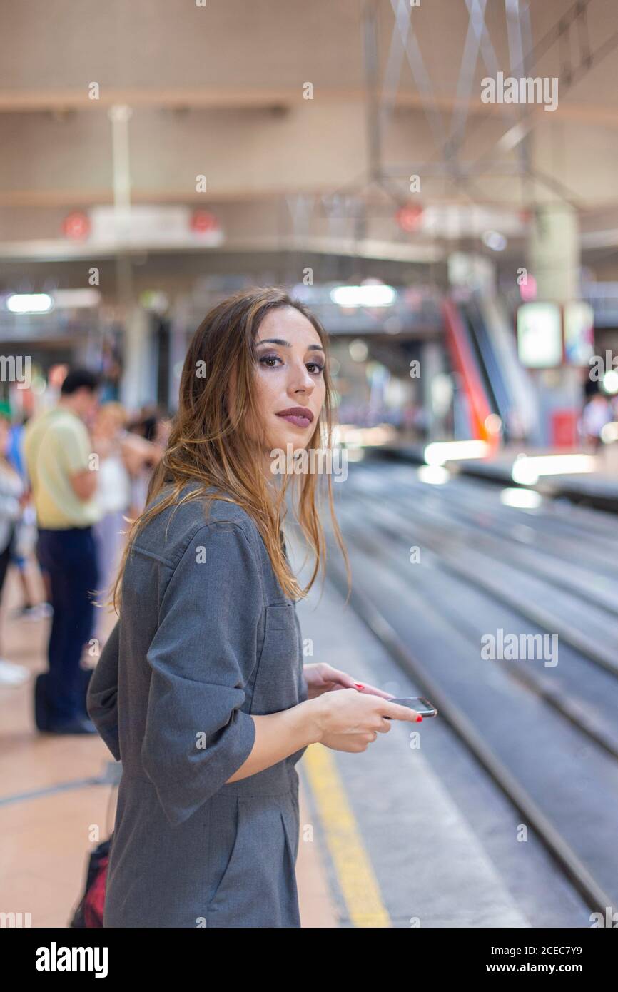 Woman using smartphone on railway station Stock Photo
