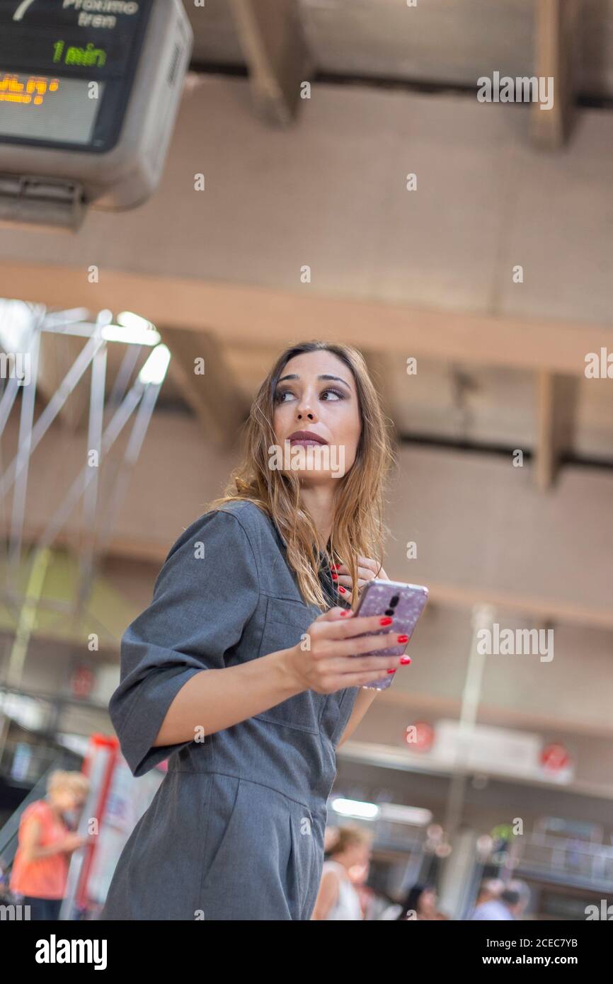 Woman using smartphone on railway station Stock Photo