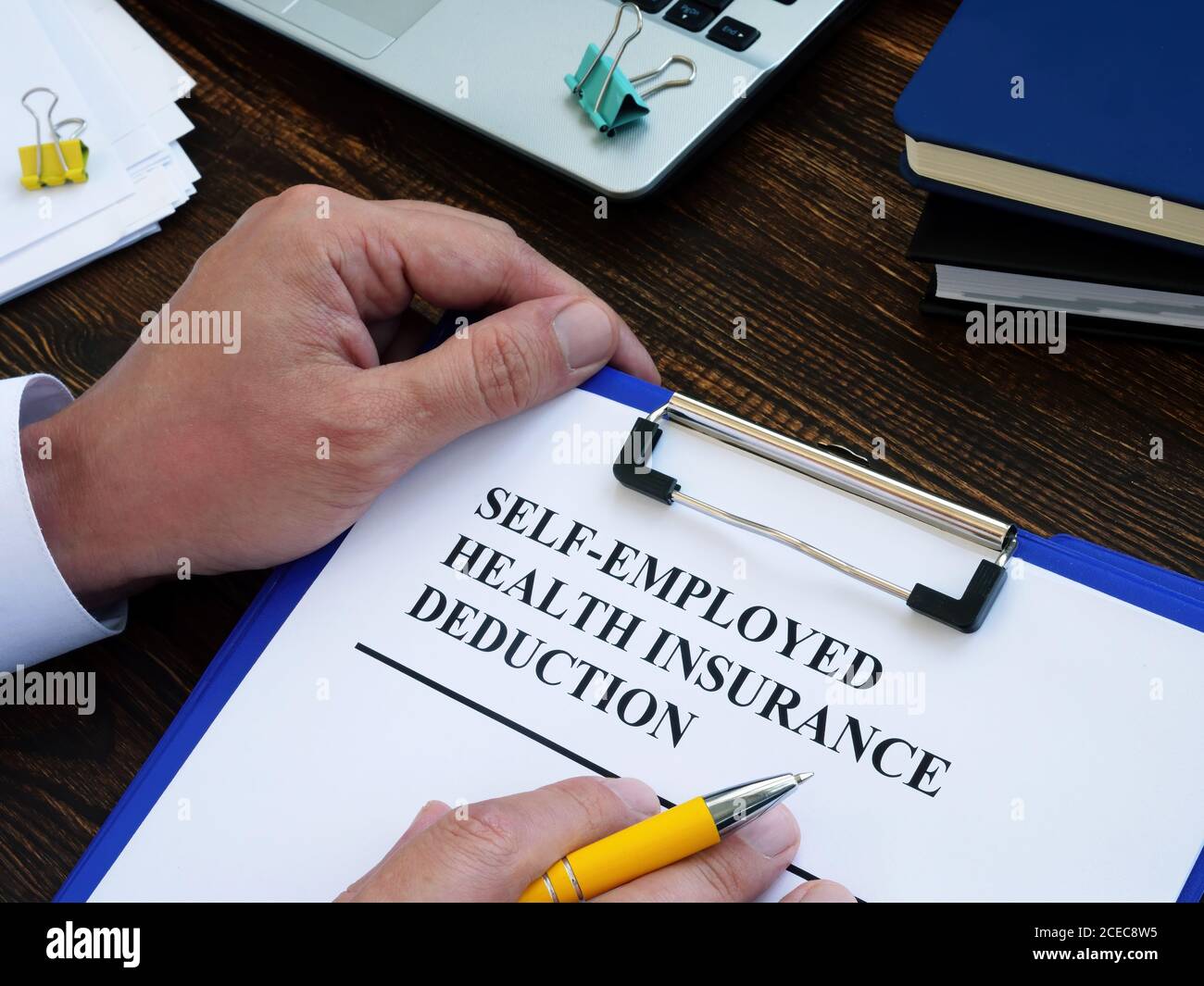 Self employed health insurance deduction application form for signing. Stock Photo