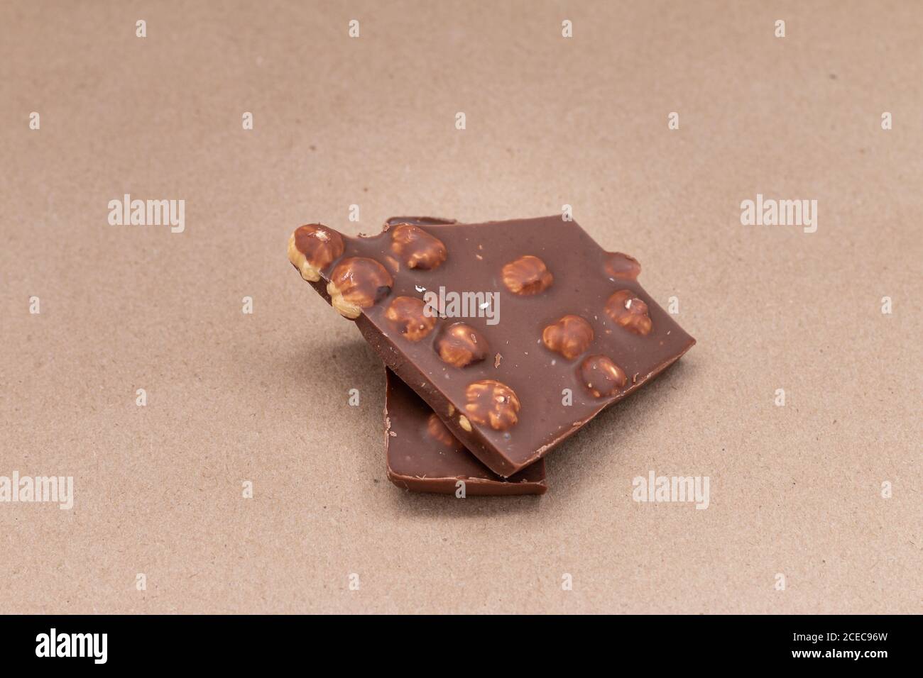 broken chocolate with hazelnuts on beige background Stock Photo
