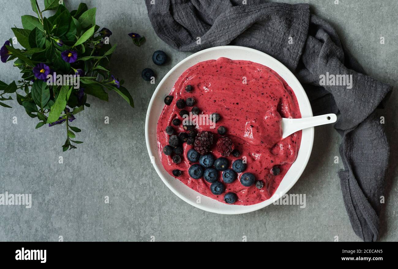 Smoothy of fresh bog blueberries and raspberries in bowl near napkin Stock Photo