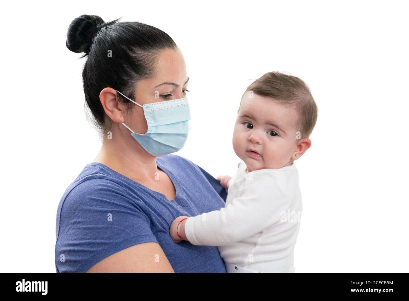 Female model as mother wearing disposable medical or surgical mask preventing covid19 sars flu coronavirus contamination holding baby girl isolated on Stock Photo