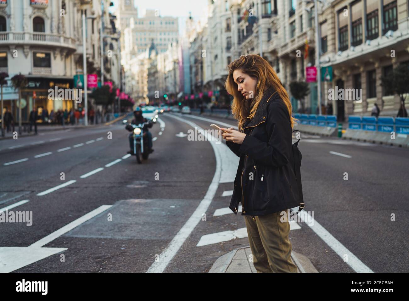 Woman using smartphone on road Stock Photo