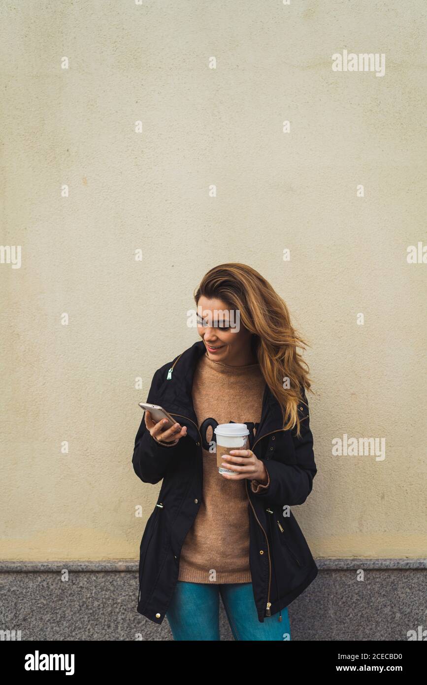 Woman with smartphone and takeaway coffee Stock Photo