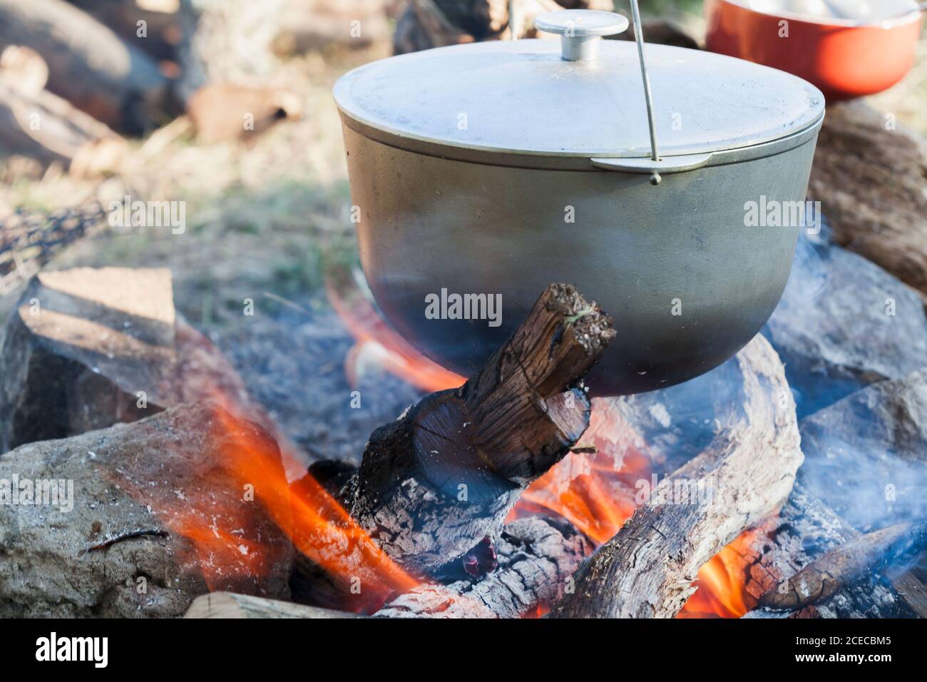 https://c8.alamy.com/comp/2CECBM5/bonfire-and-metal-cauldron-cooking-on-open-fire-camping-meal-2CECBM5.jpg