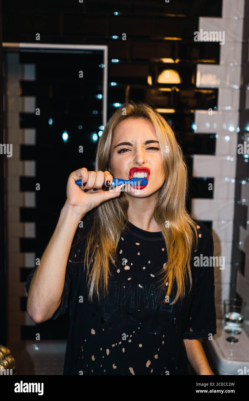 Young attractive blonde Woman posing with toothbrush and looking at camera. Stock Photo