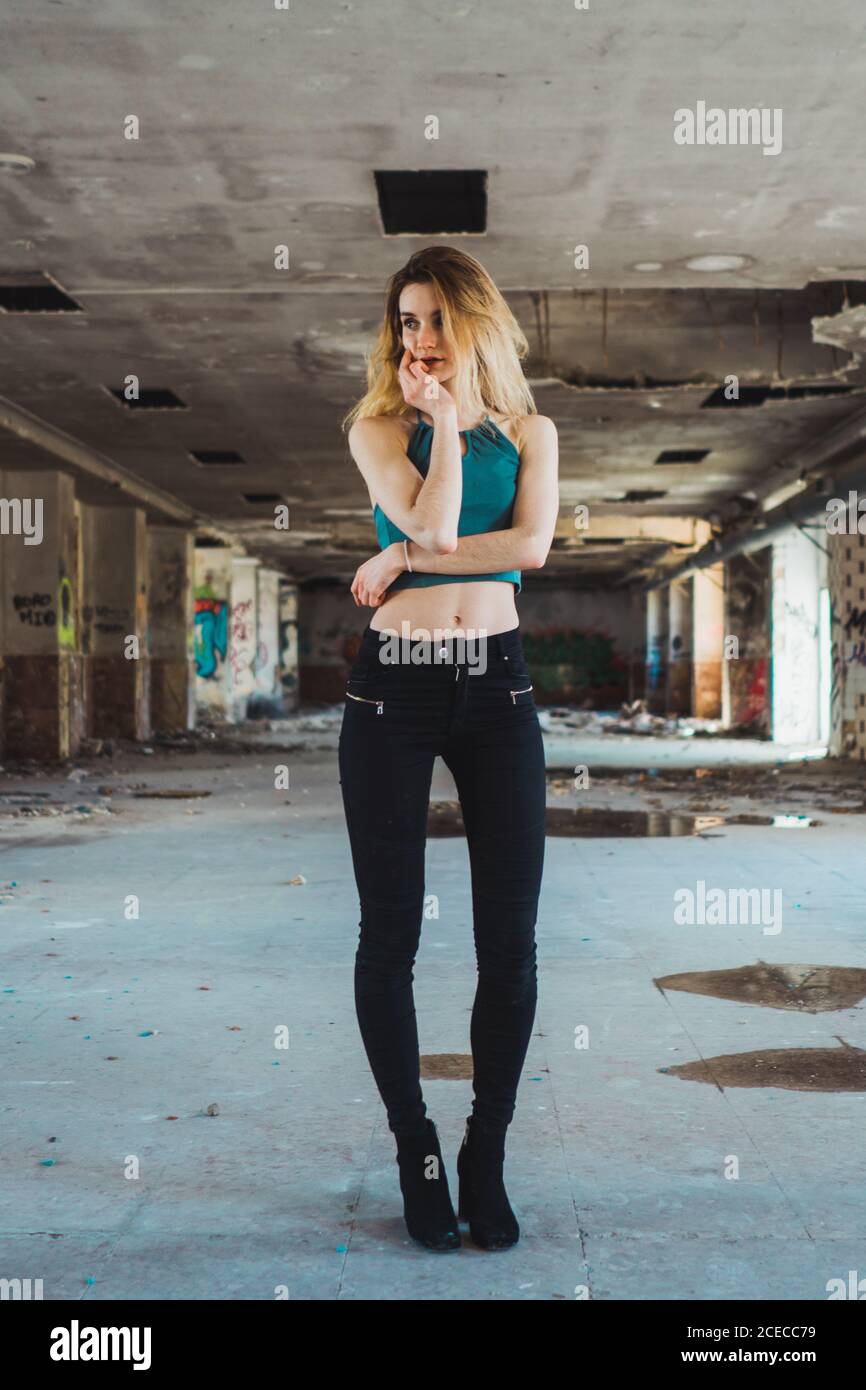 Skinny girl standing in decayed building Stock Photo