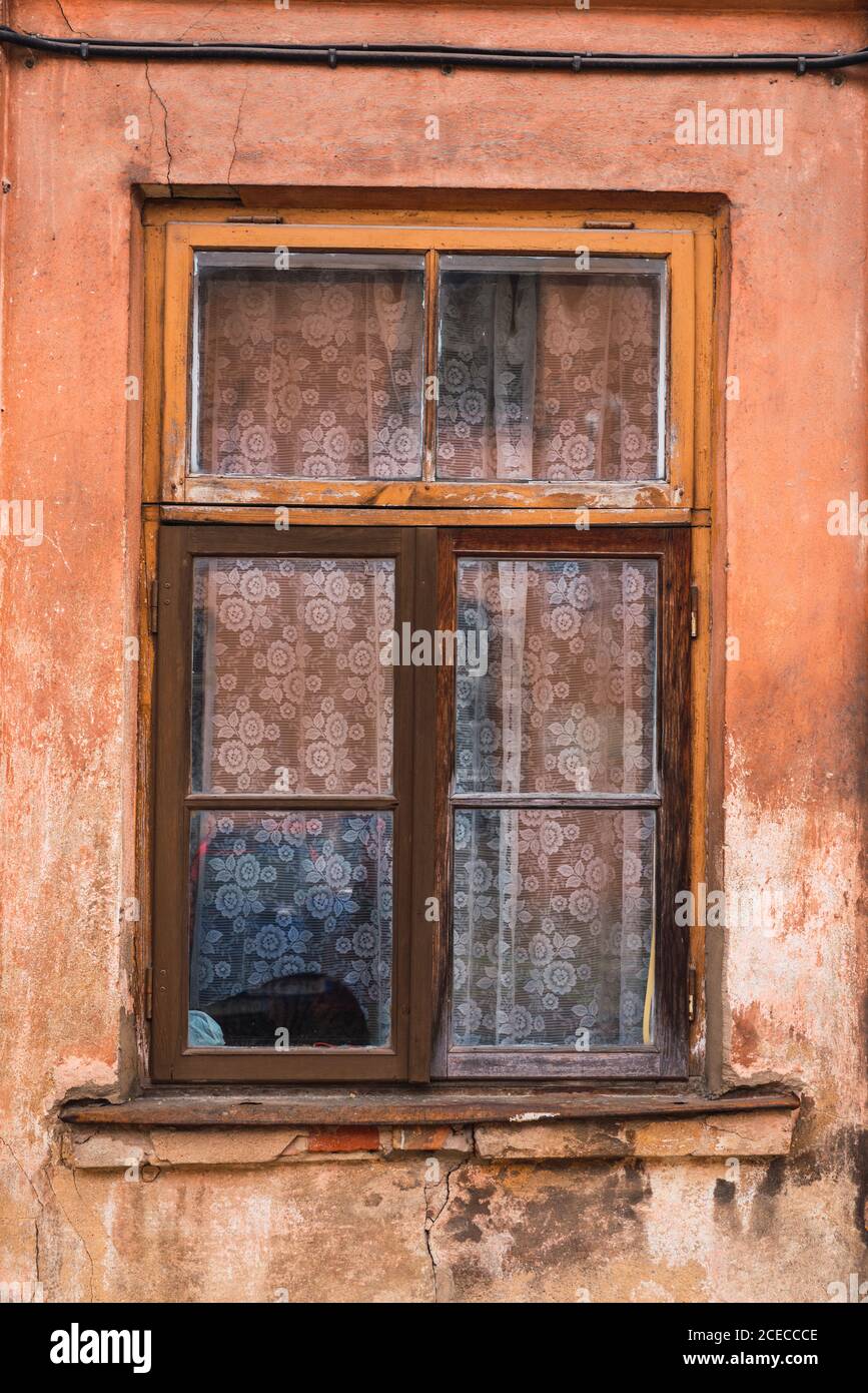 Crumbling wooden window on shabby wall of aged building in small town Stock Photo