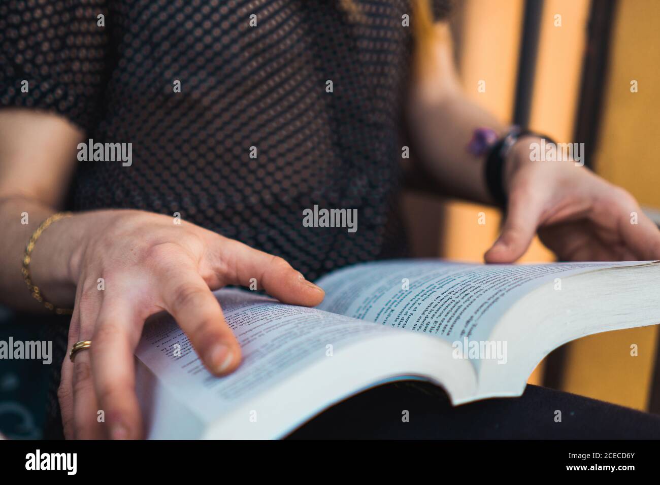 Crop unrecognizable Woman sitting on the chair and reading a book. Stock Photo