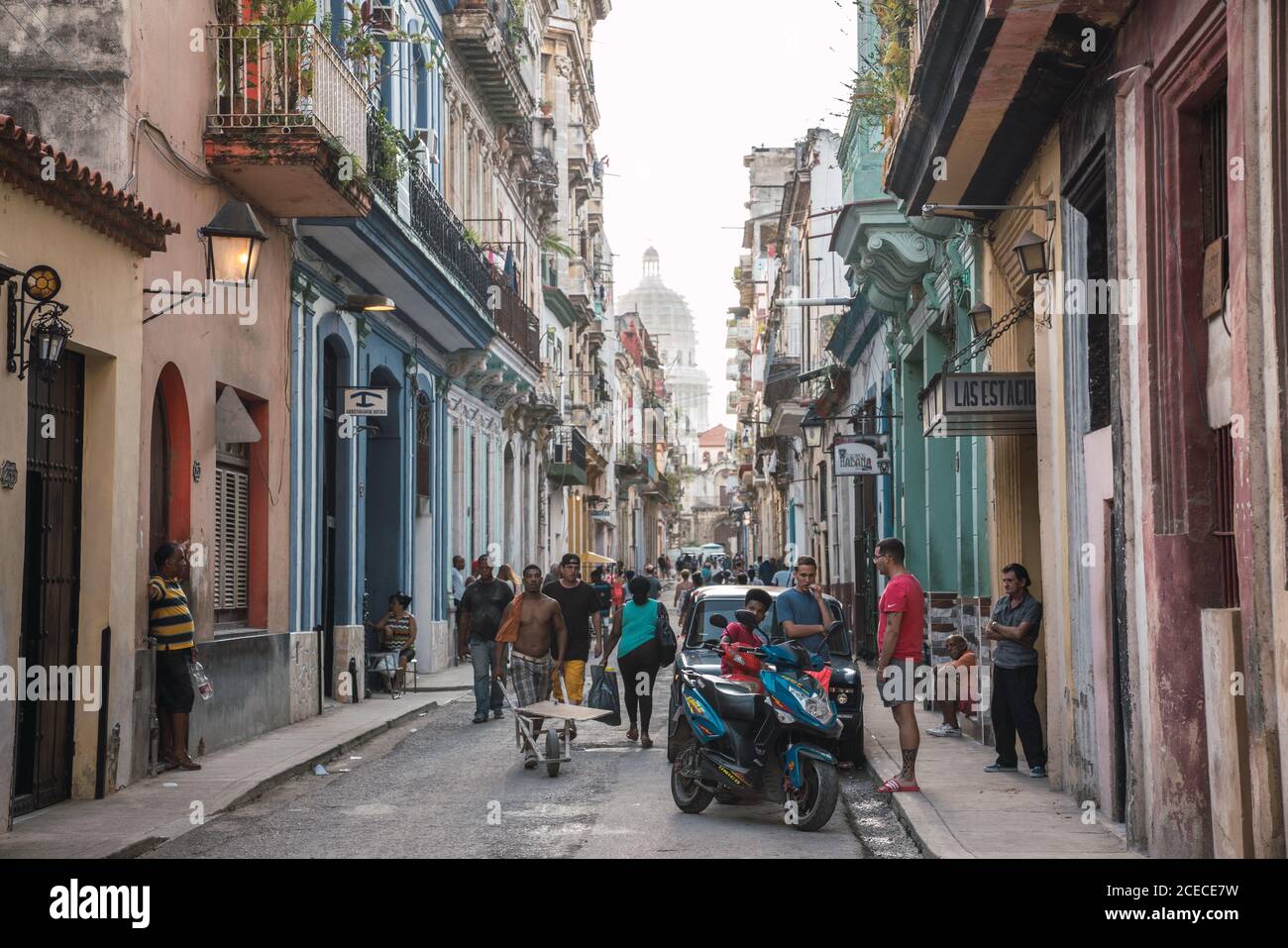LA HABANA, CUBA - NOVEMBER, 6 , 2018: many people going on street between old buildings, car and scooter in Cuba Stock Photo