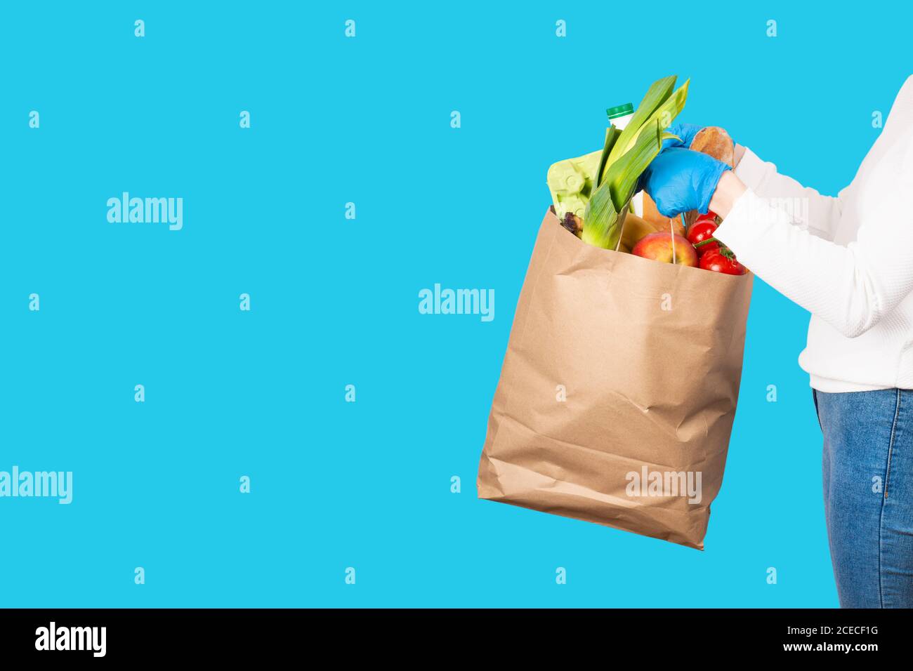 Food delivery or shopping concept. Grocery store shopping. Woman holds a paper bag filled with