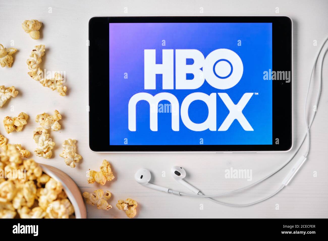 HBO MAX logo on the screen of the tablet laying on the white table and  sprinkled popcorn on it. Apple earphones near the tablet , August 2020, San  Stock Photo - Alamy