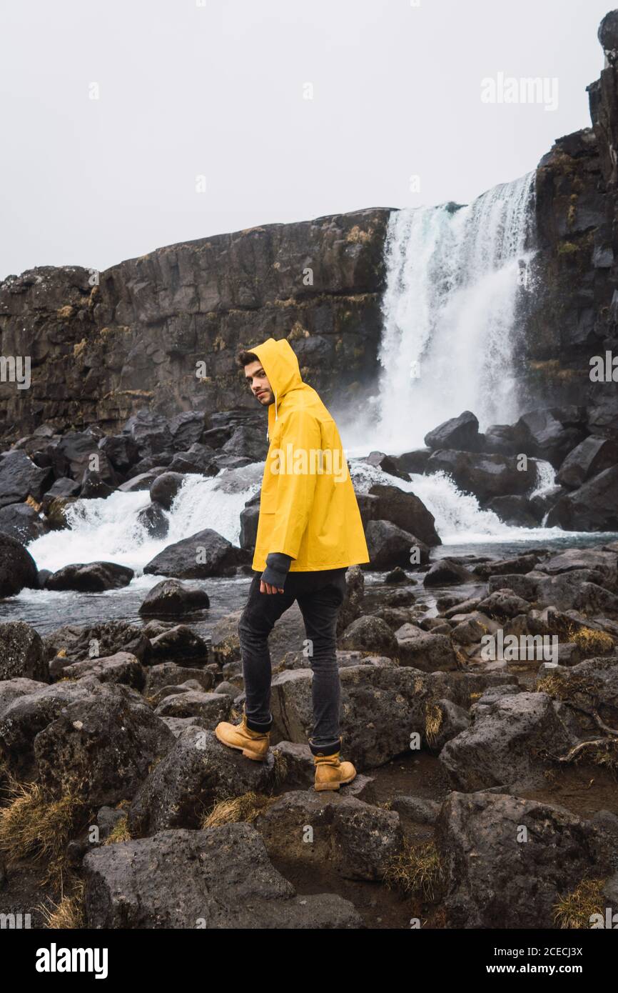 Tourist exploring rocky waterfall Stock Photo