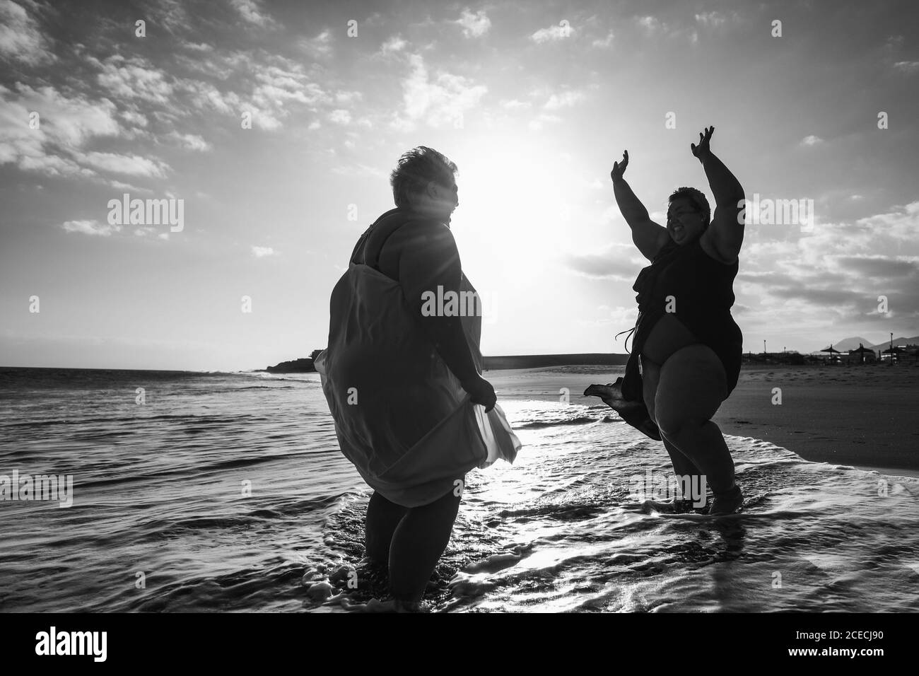 Plus size women dancing on the beach having fun during summer vacation -  Curvy female laughing together - Overweight body and happiness concept -  Blac Stock Photo - Alamy