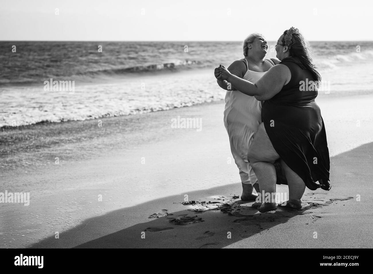 Plus size women dancing on beach fun summer vacation - female laughing together - Overweight body and happiness concept - Blac Stock Photo - Alamy