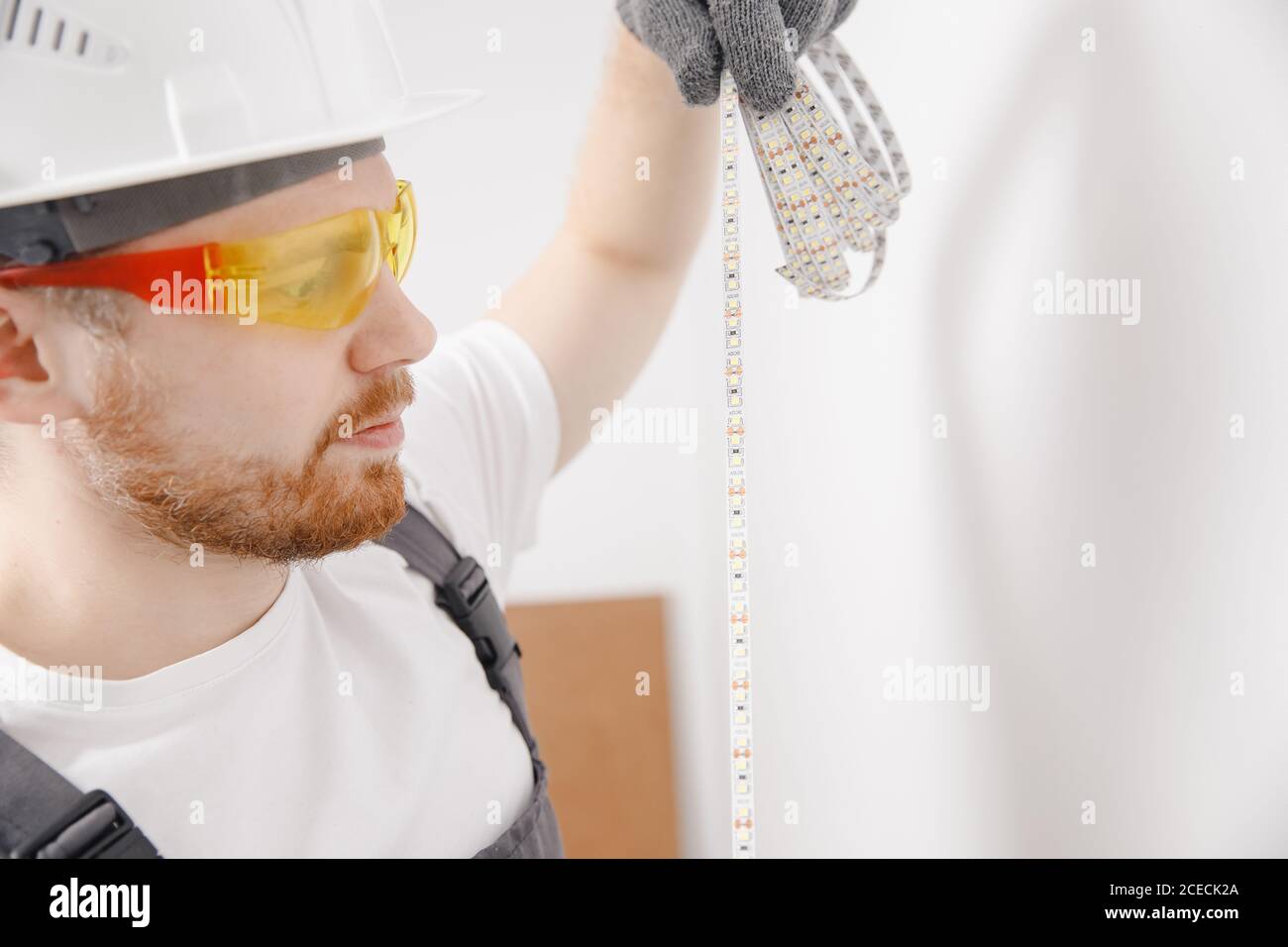 Electrician installing mounting tape LED strip light decorative