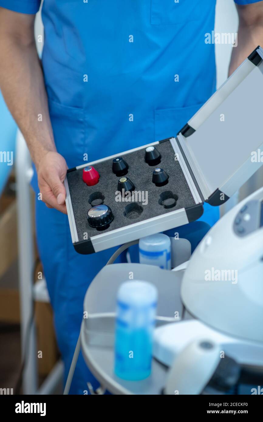 Close-up of male hands holding box with ultrasound machine changable heads Stock Photo