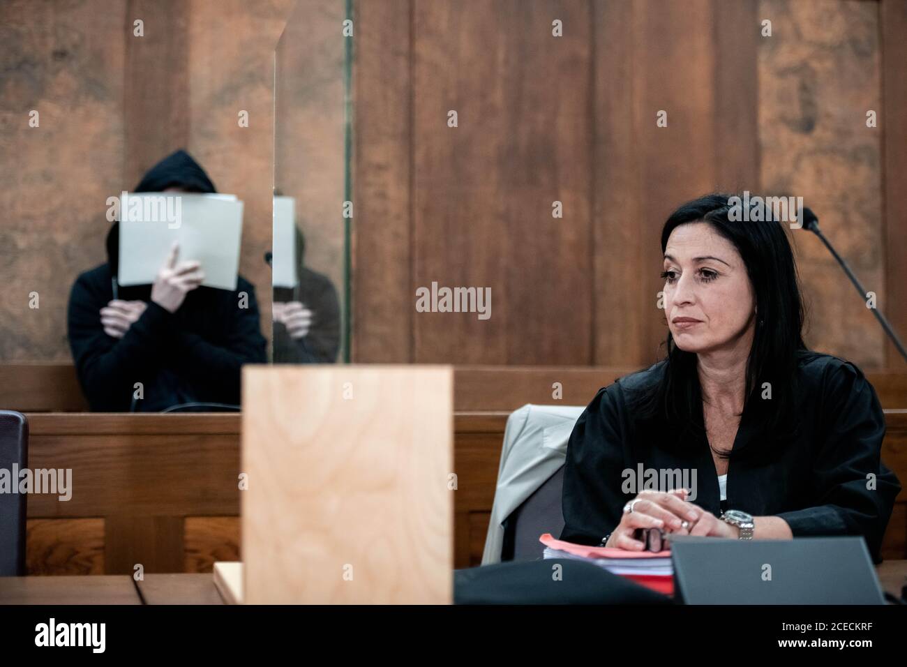 01 September 2020, North Rhine-Westphalia, Duisburg: The defendants  lawyer, Simone Dahlmann-Ludwig, sits in the courtroom in front of the  defendant who is hiding his face. The trial on the violent death of