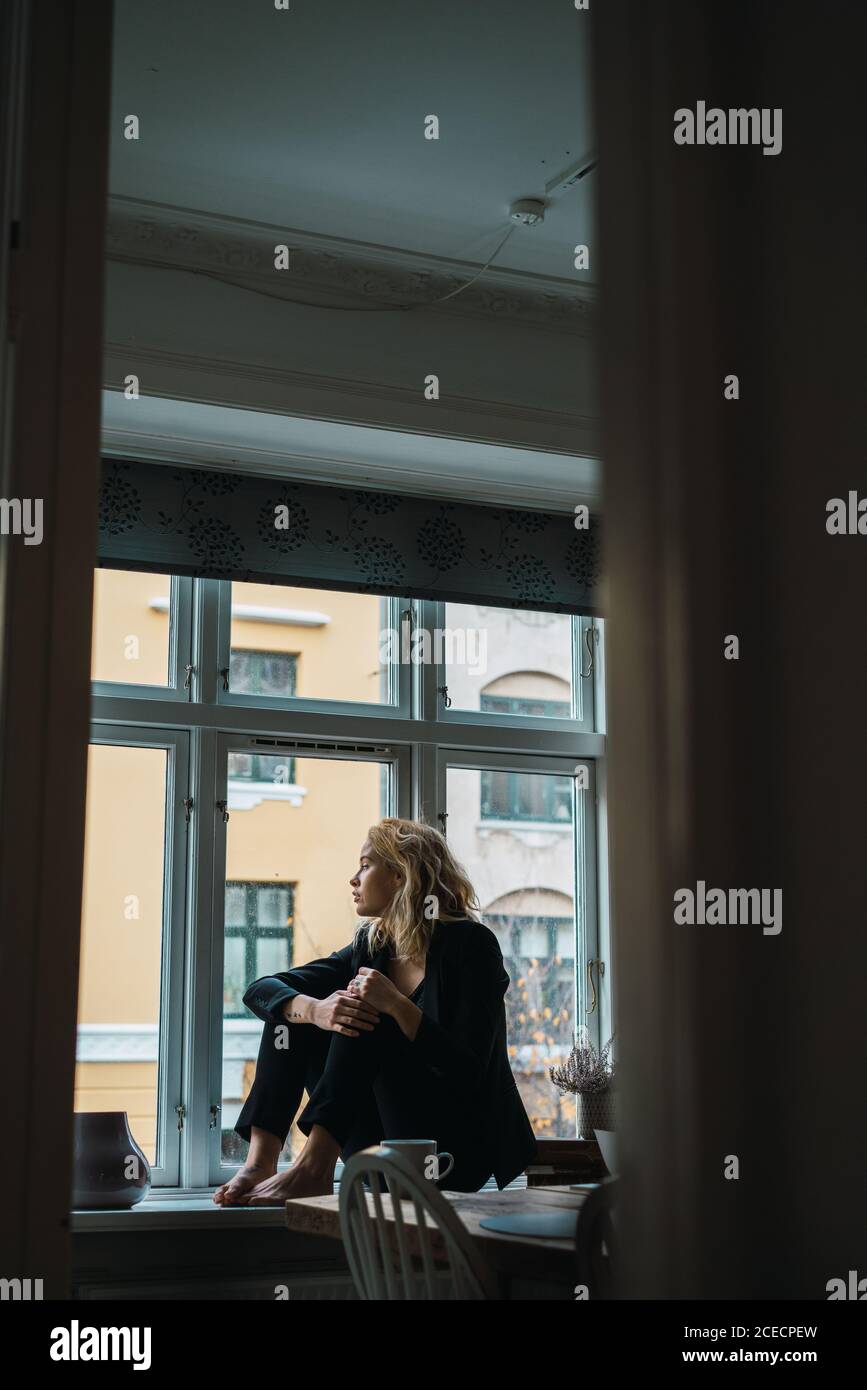 Romantic Woman posing on windowsill Stock Photo