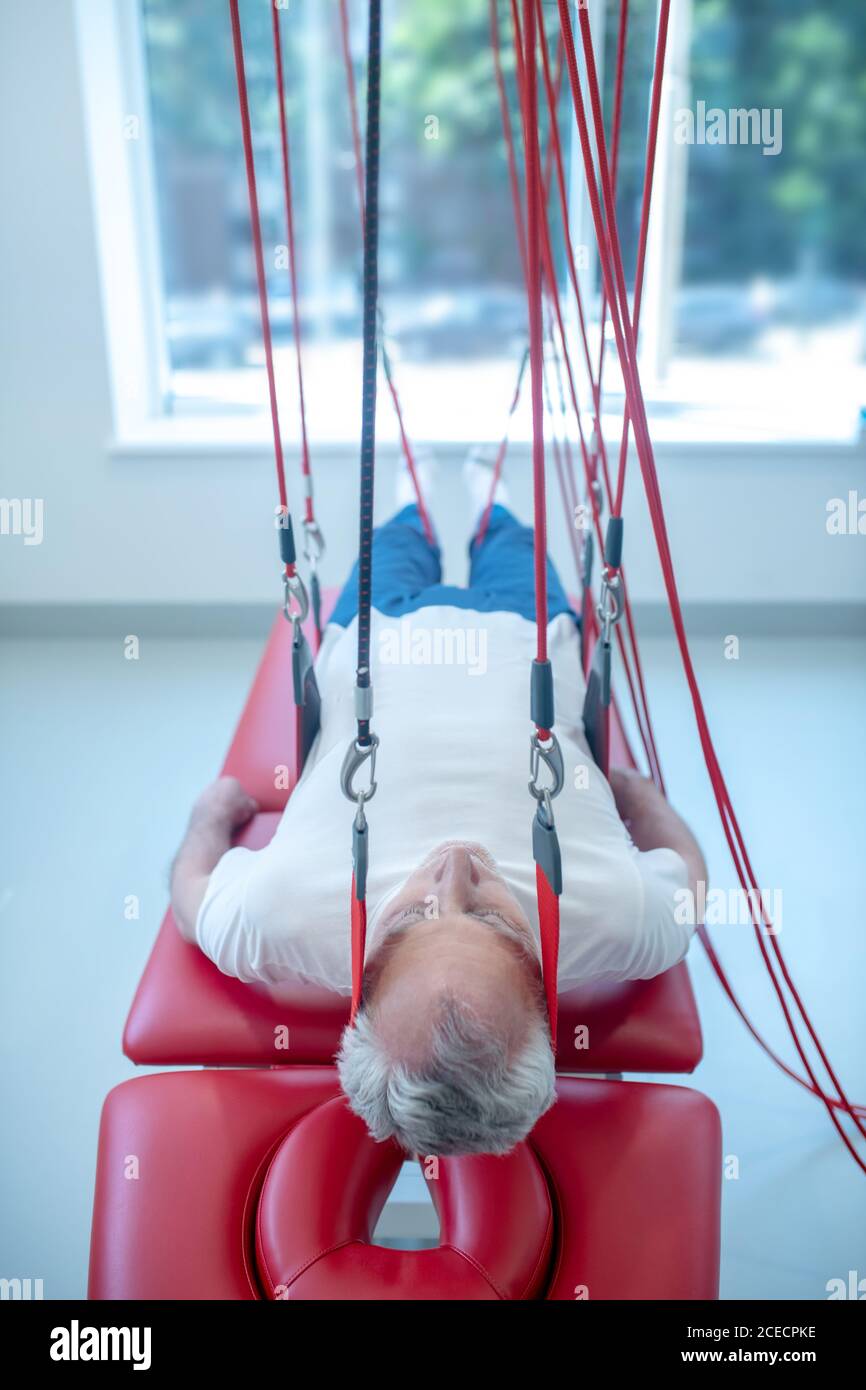 Elderly man over couch at medical center in rehabilitation Stock Photo
