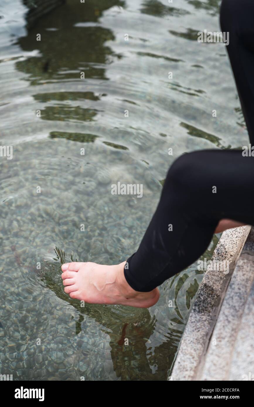 Woman legs in black tights put in clean pond Stock Photo