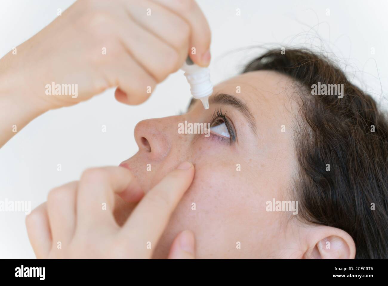 woman using eye drop, woman dropping eye lubricant to treat dry eye or
