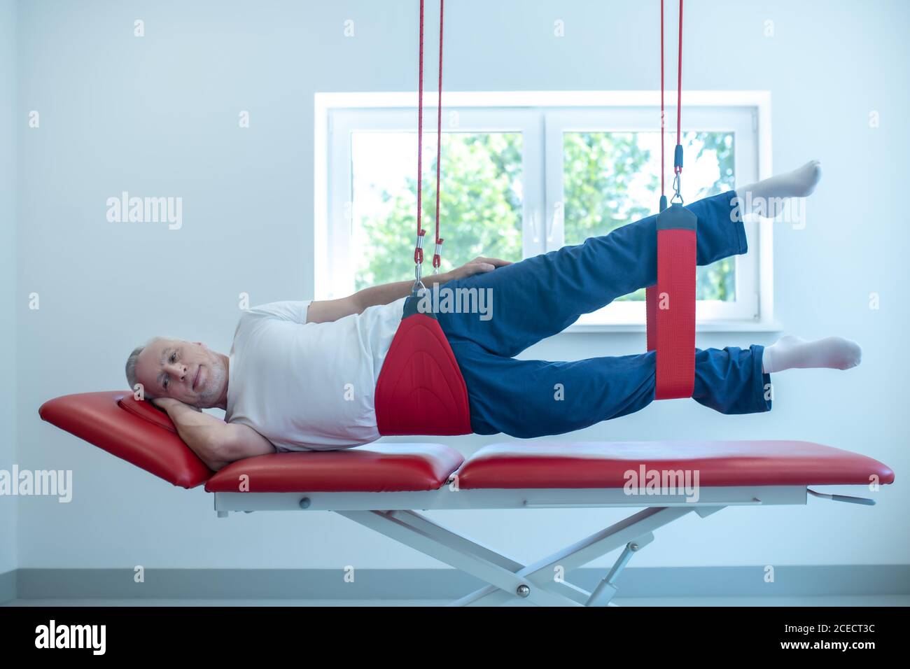 Man on his side on couch in rehabilitation center Stock Photo