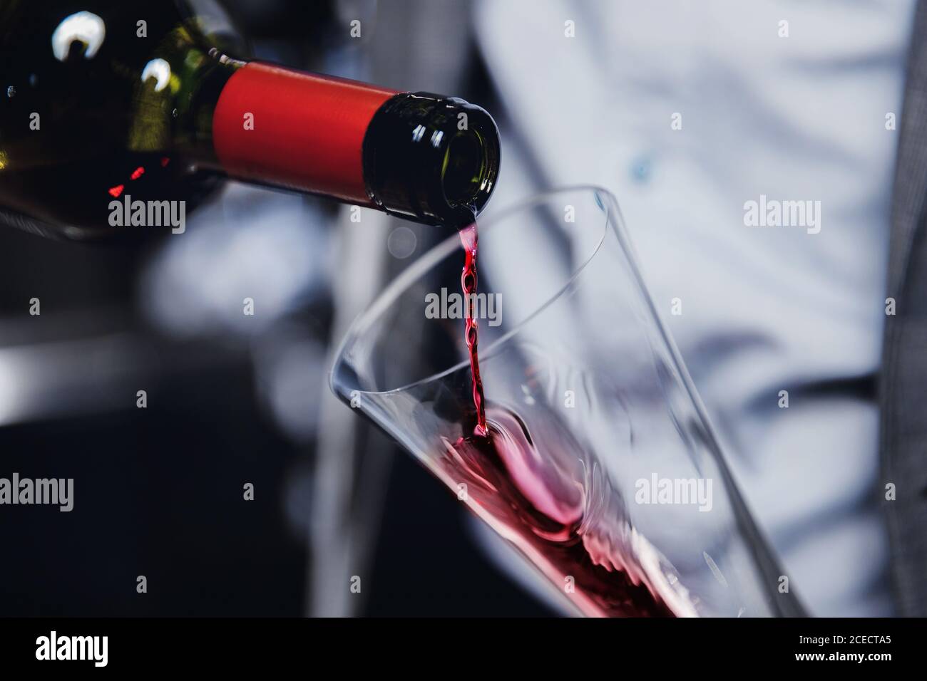 Sommelier man pours red wine into decanter for aeration of taste and aroma Stock Photo