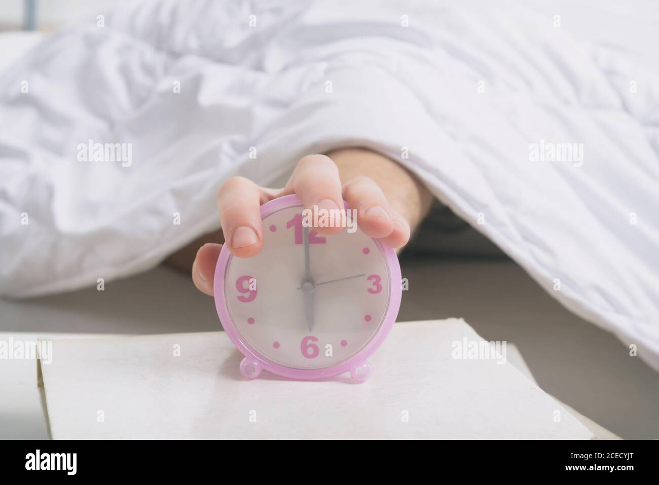 Hand on clock, time to wake up Stock Photo