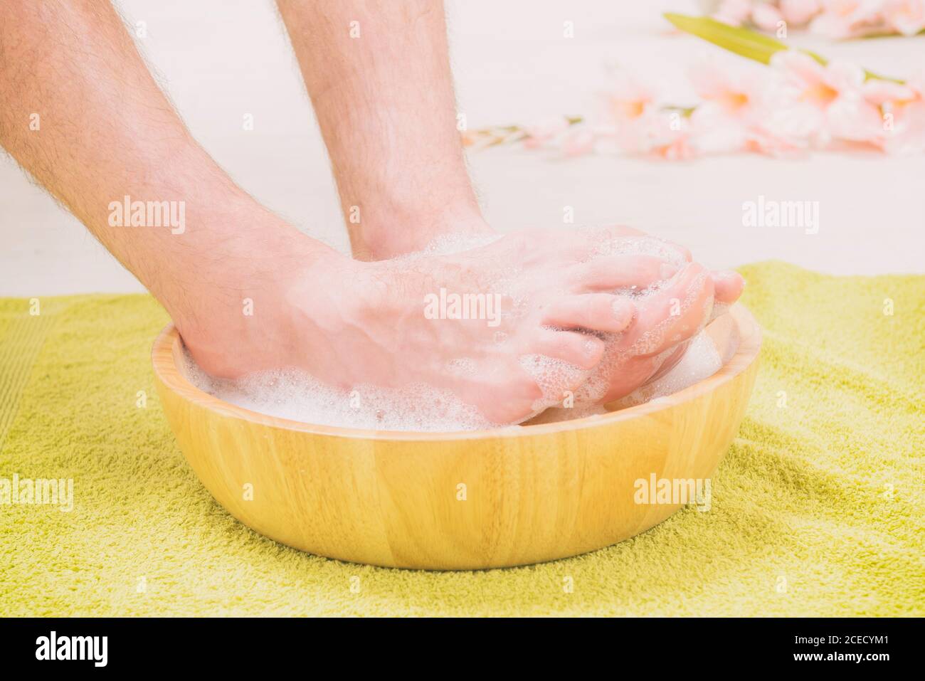 Male feet in a bowl with water and soap, hygiene and spa concept Stock