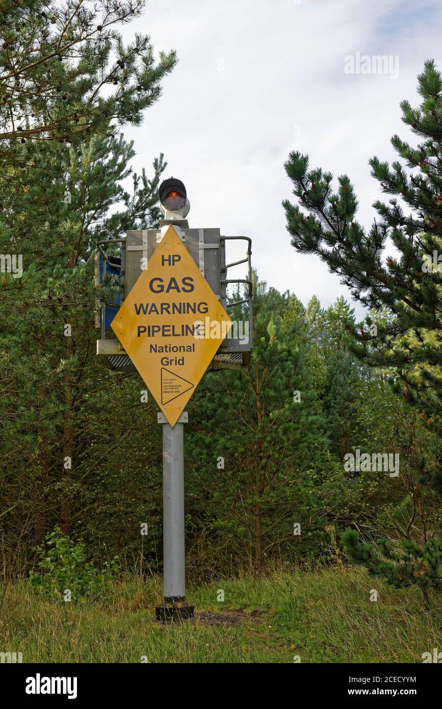 A substantial Metal Marker with a Yellow Warning sign marking the point at which a Gas line crosses the Tay Estuary at Tentsmuir Forest. Stock Photo