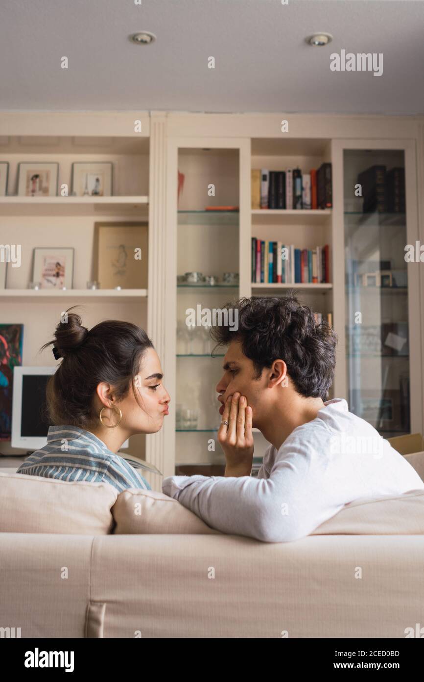Cheerful young couple sitting on couch Stock Photo