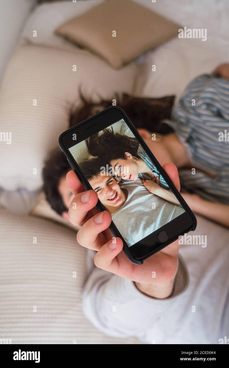 Couple taking selfie on bed Stock Photo