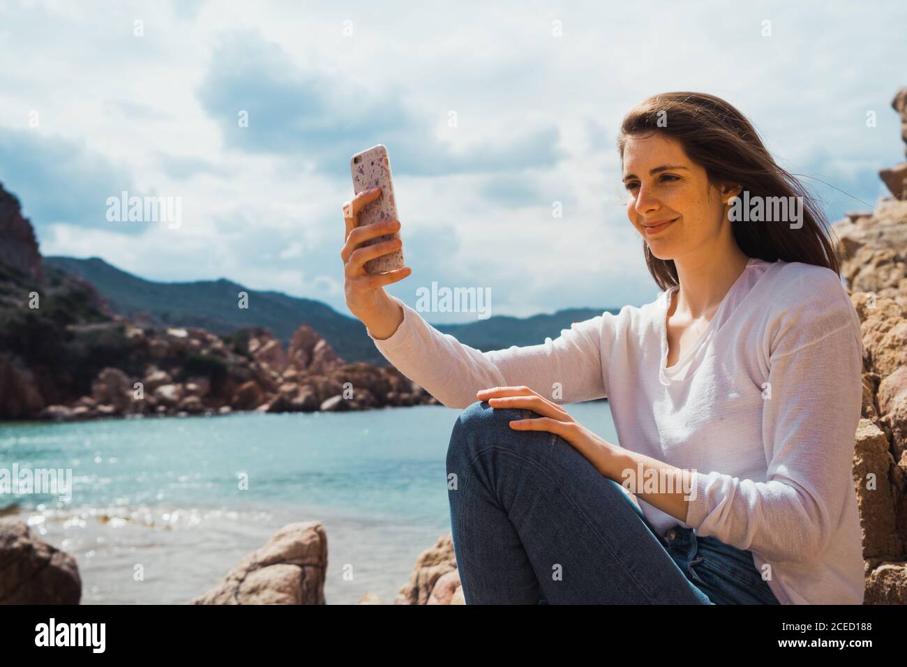 Woman taking selfie with smartphone at seaside Stock Photo