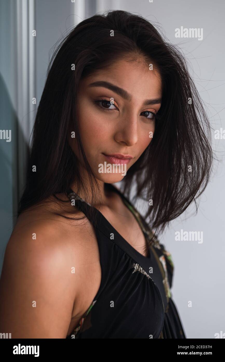 Side view beautiful passionate brunette Hispanic Woman in black wear Stock Photo
