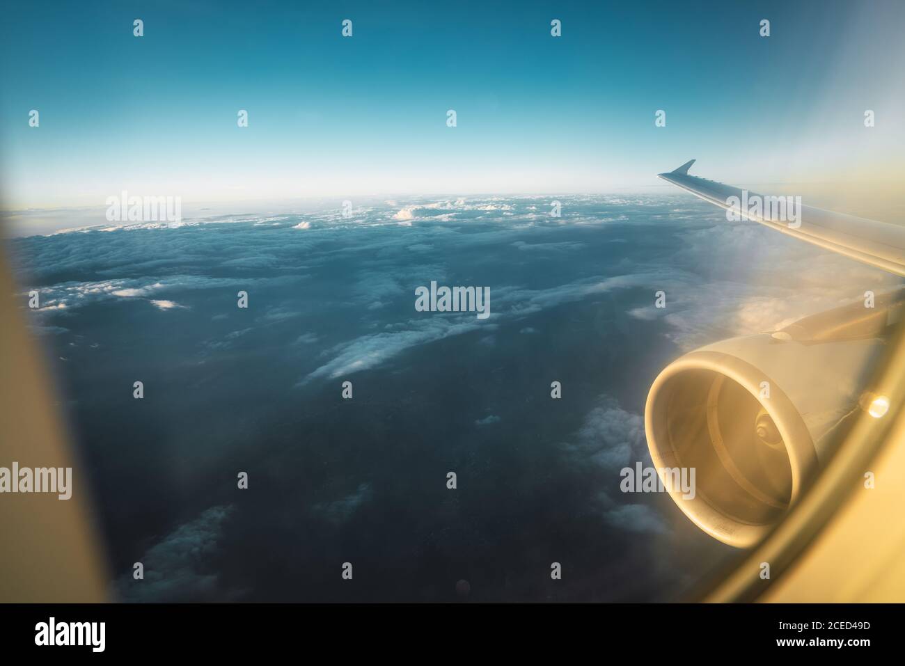 Shot through glass of plane glass with aircraft wing and turbine flying