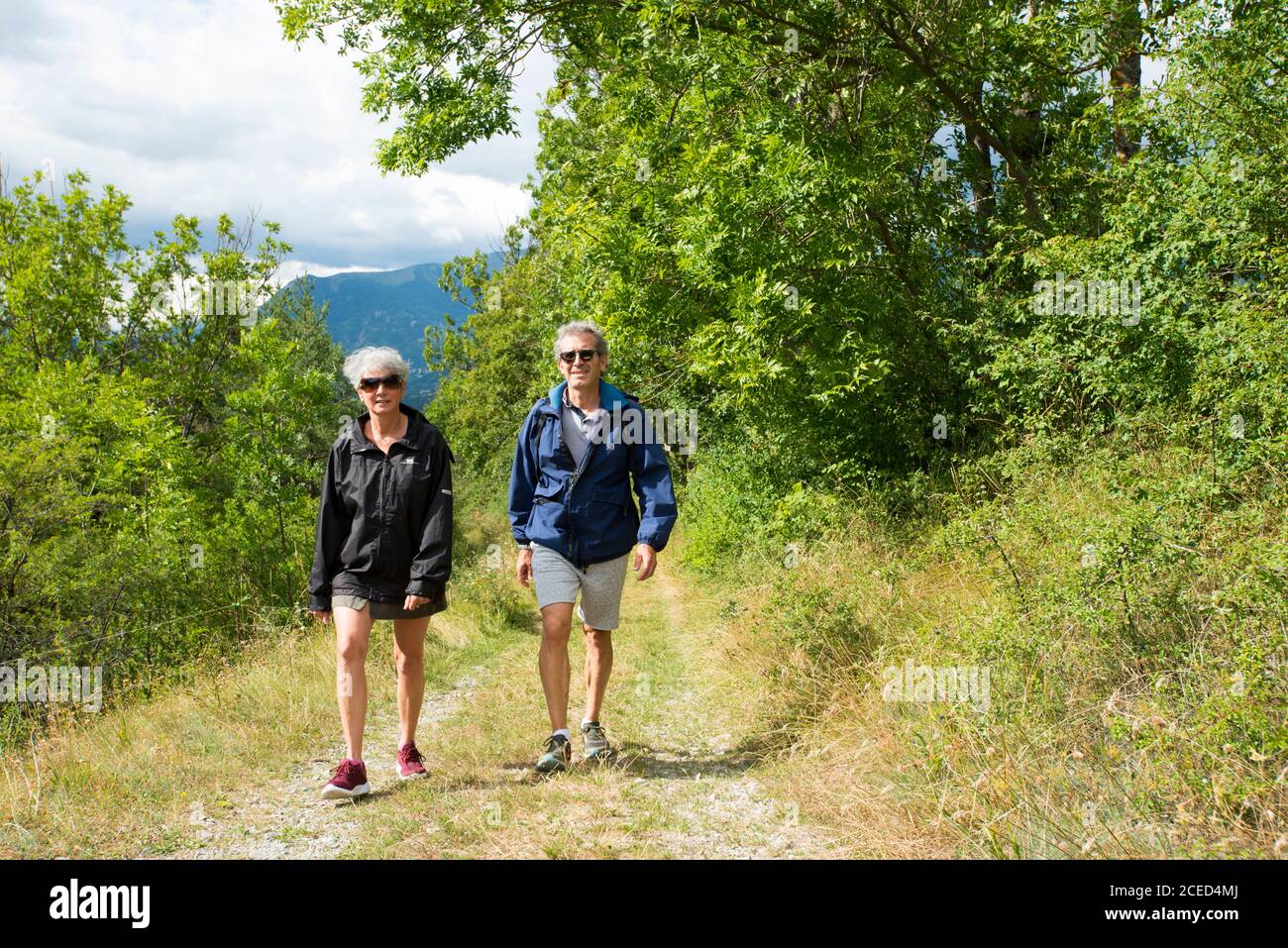 Two tourists hiking in the French Alps Stock Photo